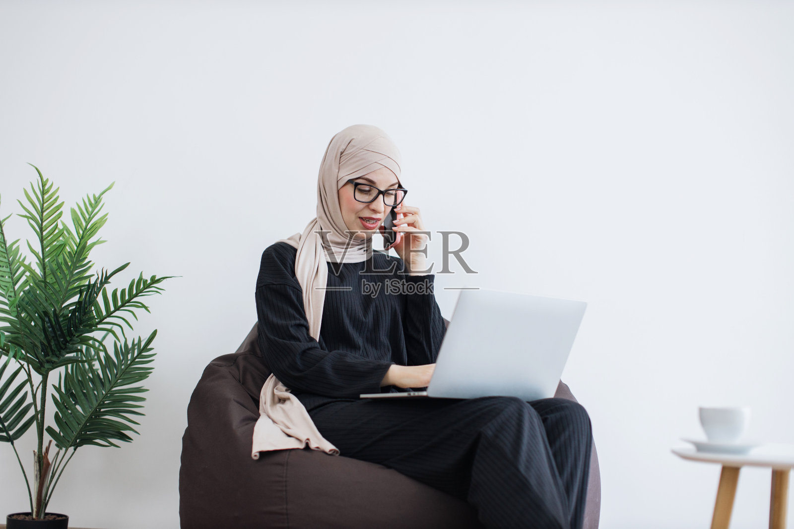 工作时跪在地上用智能手机和笔记本电脑聊天照片摄影图片