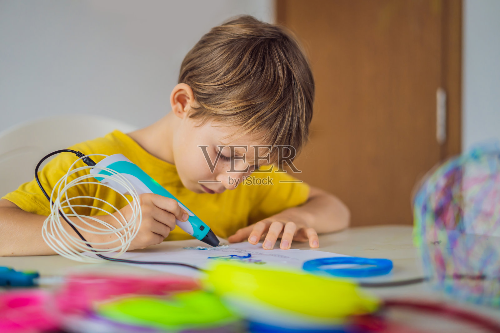 小朋友使用3d打印画笔。创意、休闲、科技的教育理念照片摄影图片