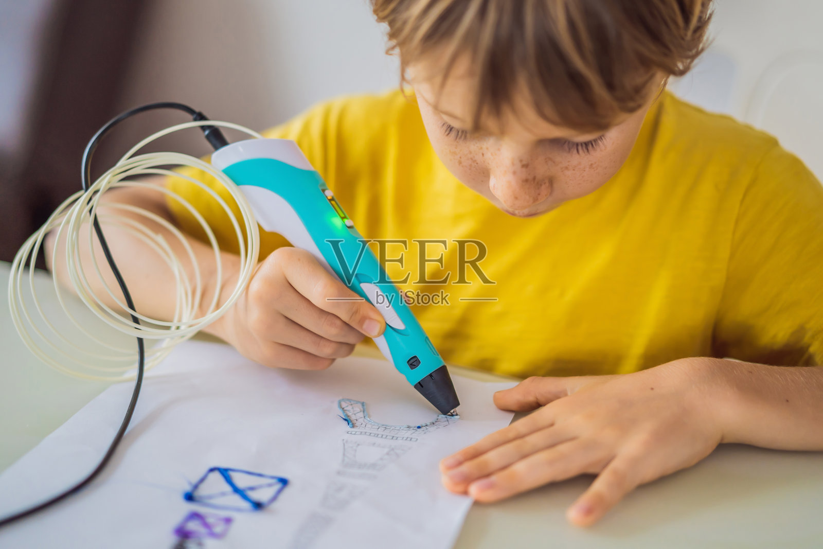 小朋友使用3d打印画笔。创意、休闲、科技的教育理念照片摄影图片