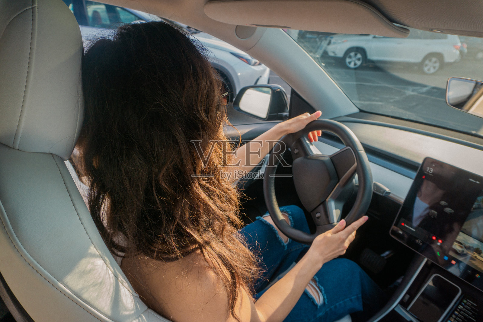 一个夏天的周末，年轻女子在开车时用手握着方向盘。旅行探险自驾，快乐暑假理念照片摄影图片