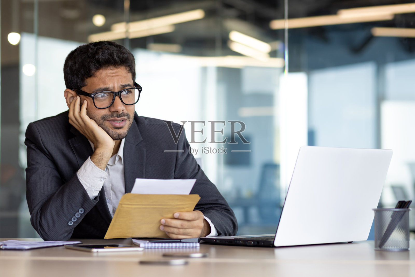 年轻商人对成就结果感到沮丧和失望，收到邮件消息，西班牙裔男子拼命阅读新闻，该男子在办公室里用笔记本电脑工作照片摄影图片