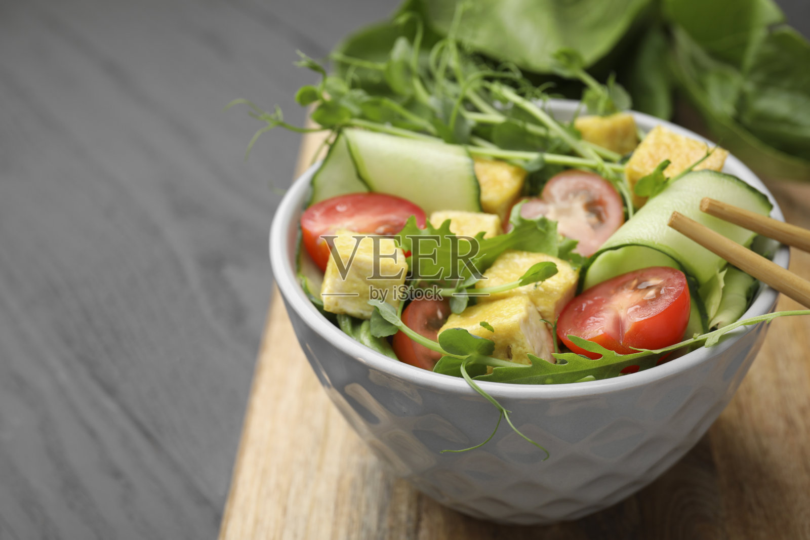 灰色木桌上，一碗美味的豆腐蔬菜沙拉，特写。文本空间照片摄影图片