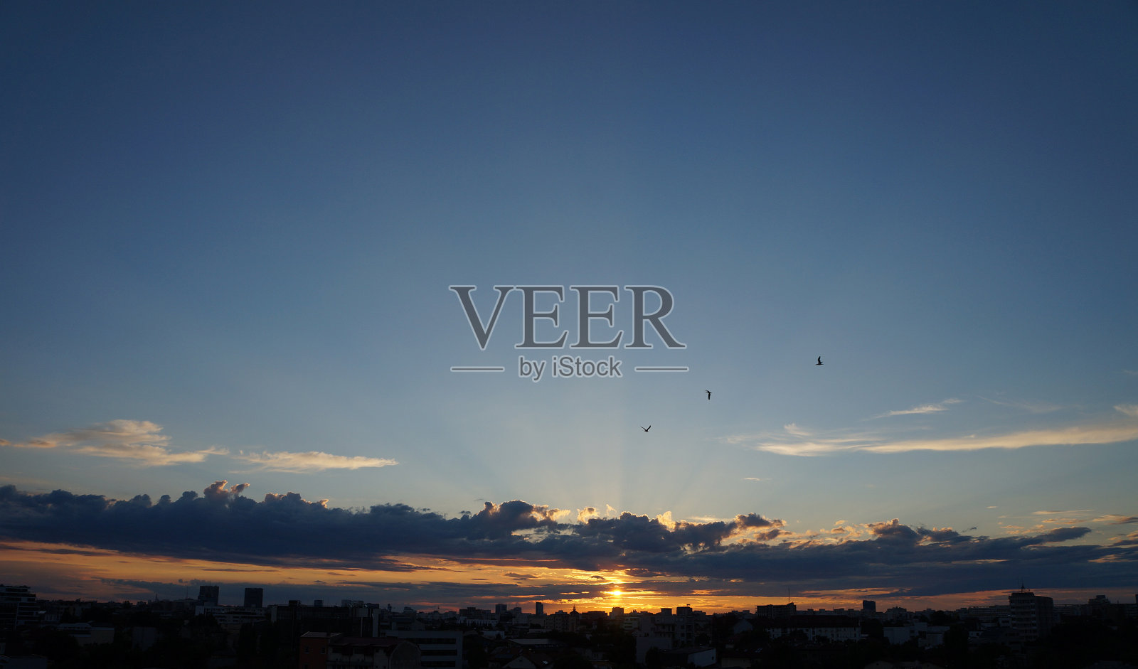 日落时布加勒斯特的天际线，日出时天空有云。布加勒斯特市上空紫色的夕阳照片摄影图片