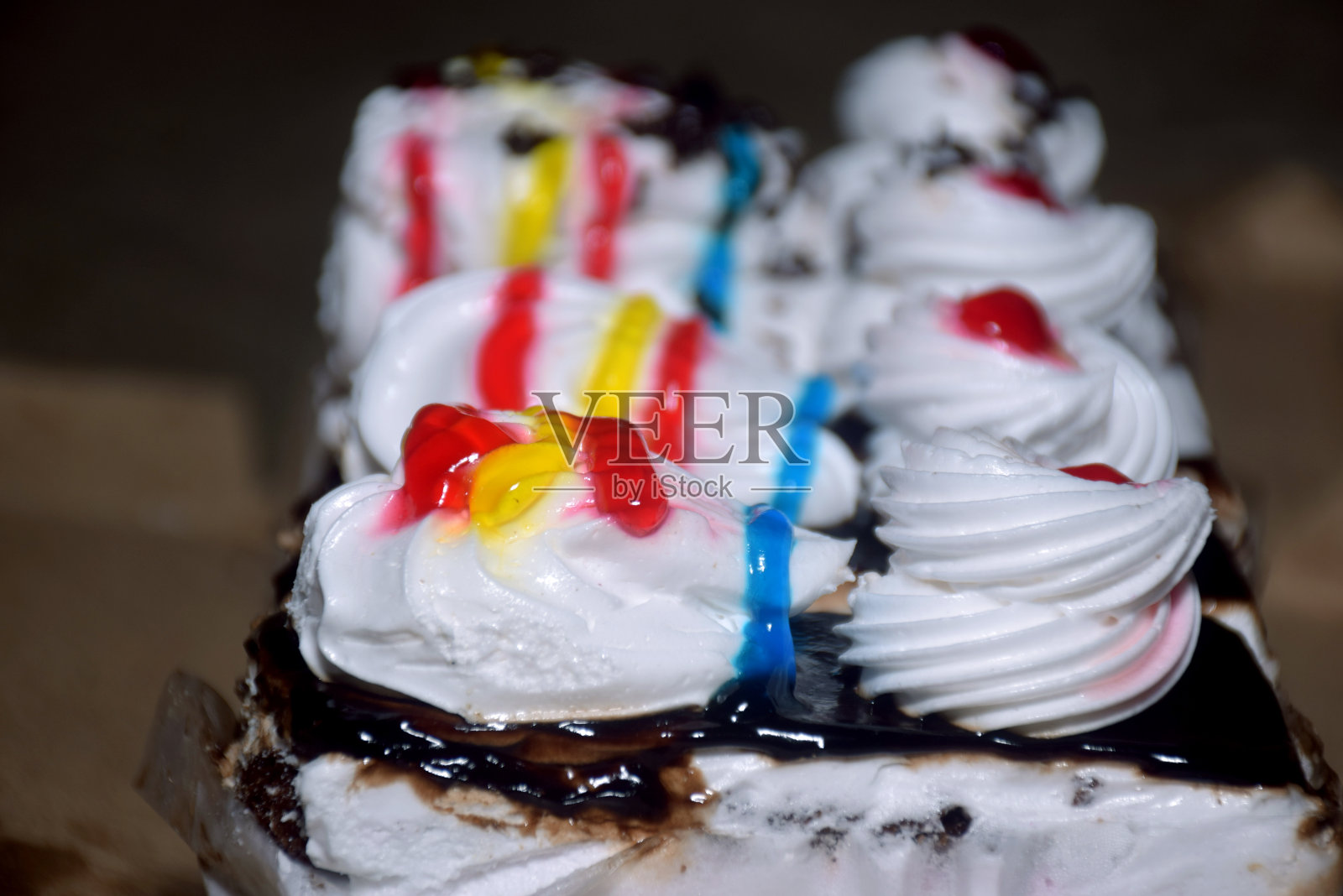 各种蛋糕，彩虹蛋糕，覆盆子蛋糕和杏仁蛋糕。为节日装饰的糖果照片摄影图片