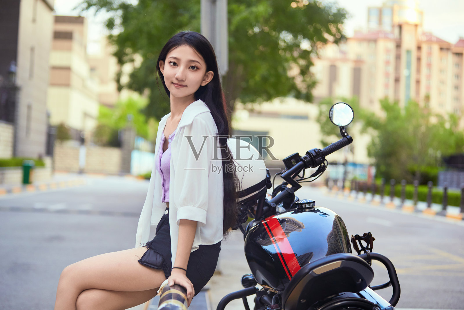 一个亚洲女孩在户外骑摩托车照片摄影图片