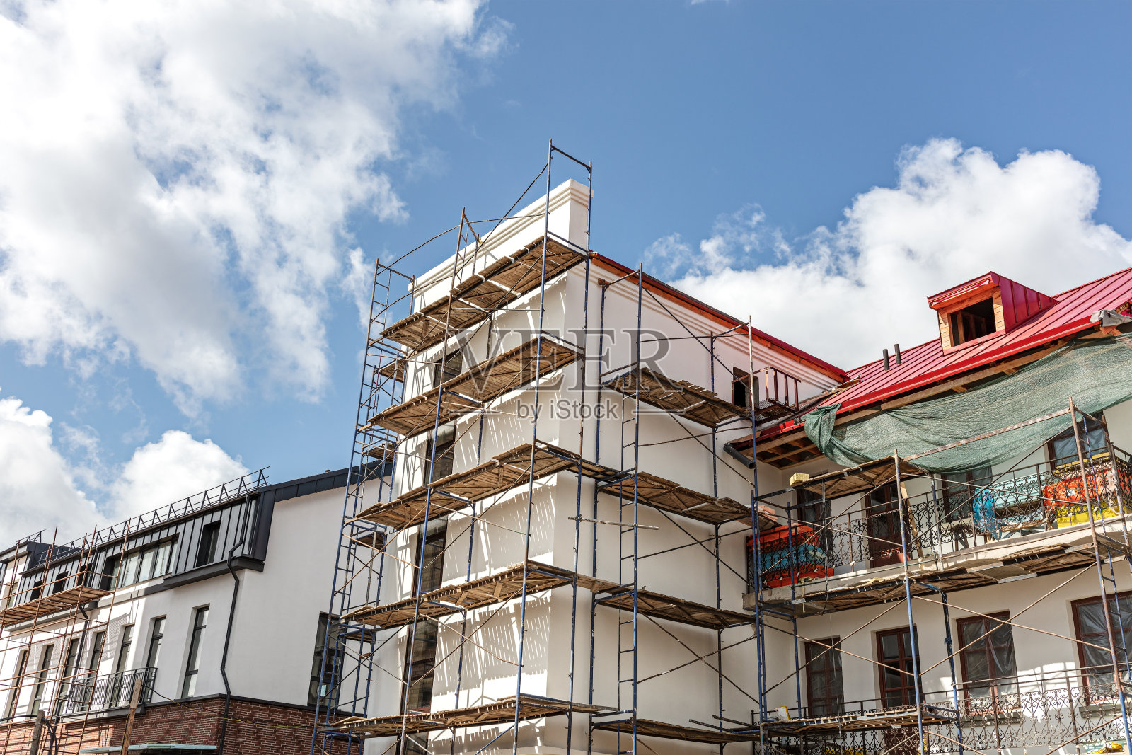 旧楼翻新。建筑外立面周围的脚手架。照片摄影图片