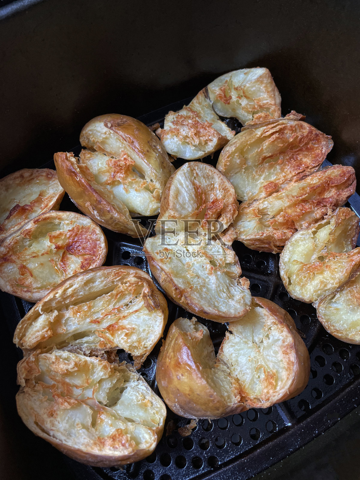 特写图片是金黄的、新鲜的、带皮的烤土豆，在空气炸锅里煮，比烤箱烤更健康照片摄影图片