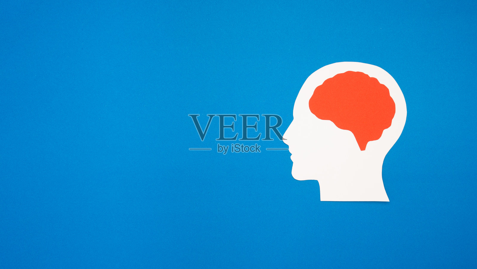 在蓝色背景上用纸做成的大脑形状照片摄影图片