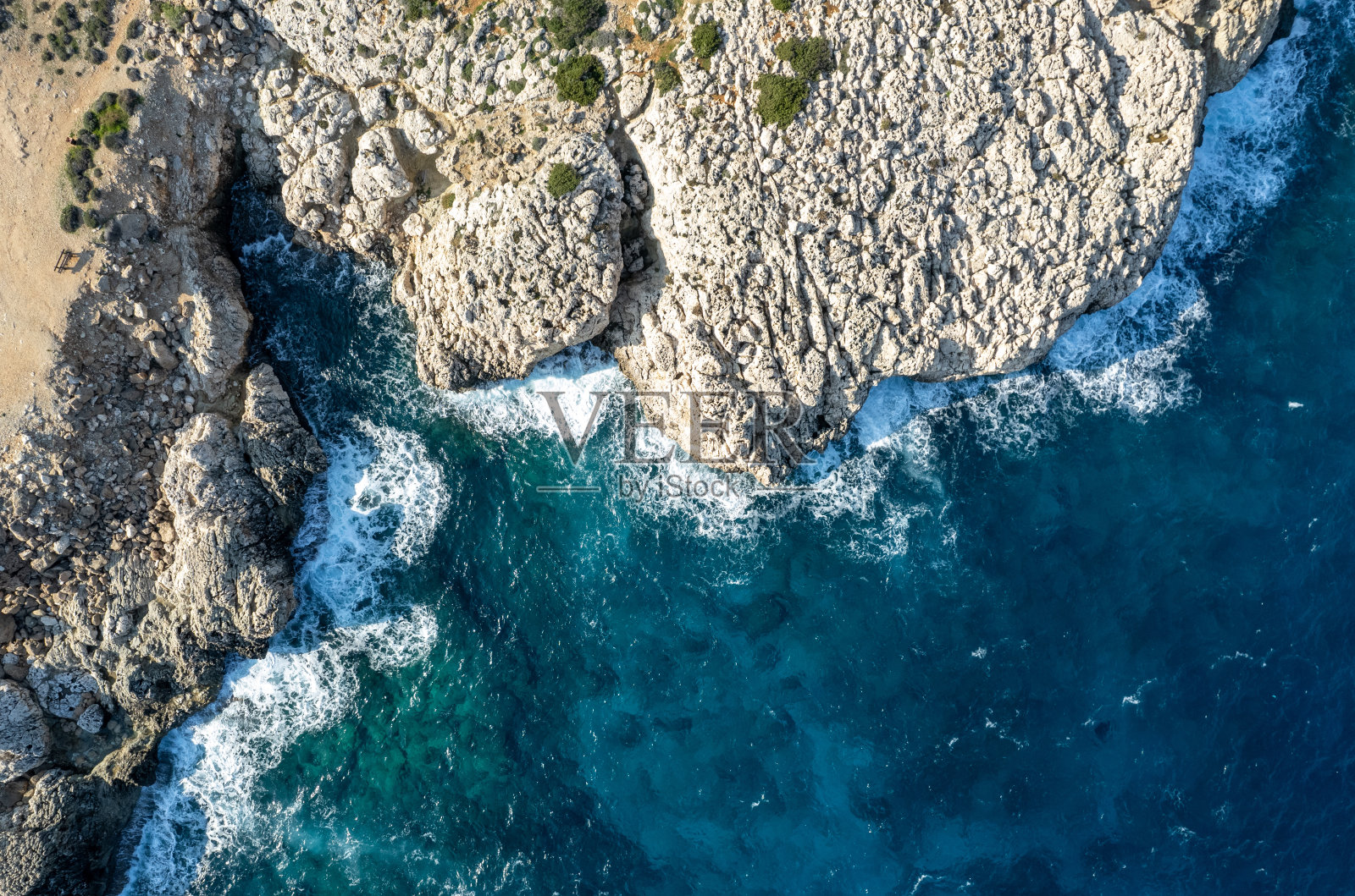 无人机拍摄的岩石海岸和透明的绿松石水。海景俯视图。照片摄影图片