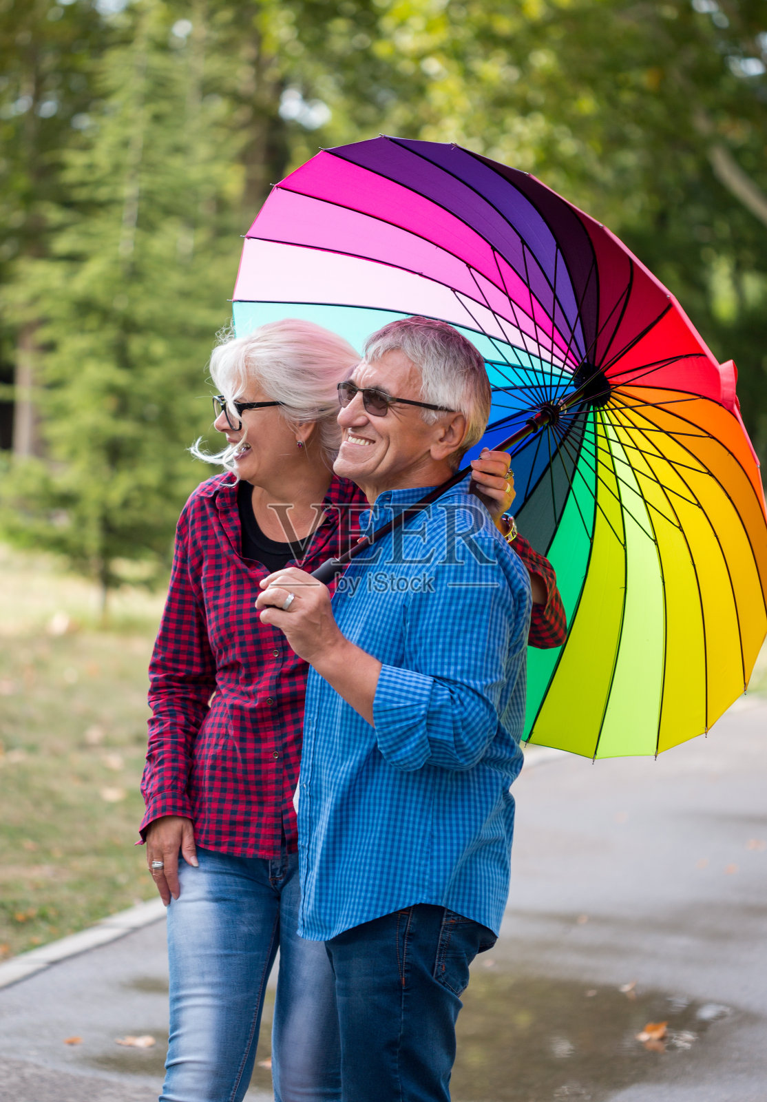 一对情侣在秋天的公园里撑伞照片摄影图片