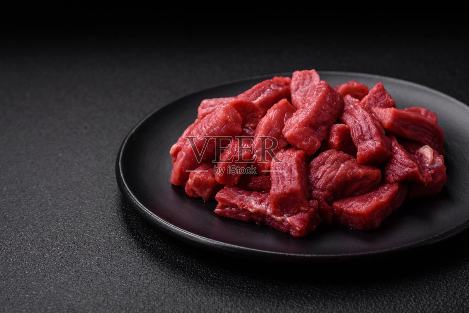 用盐、香料和草药切成片的生的有机肉、牛肉或羊肉照片摄影图片