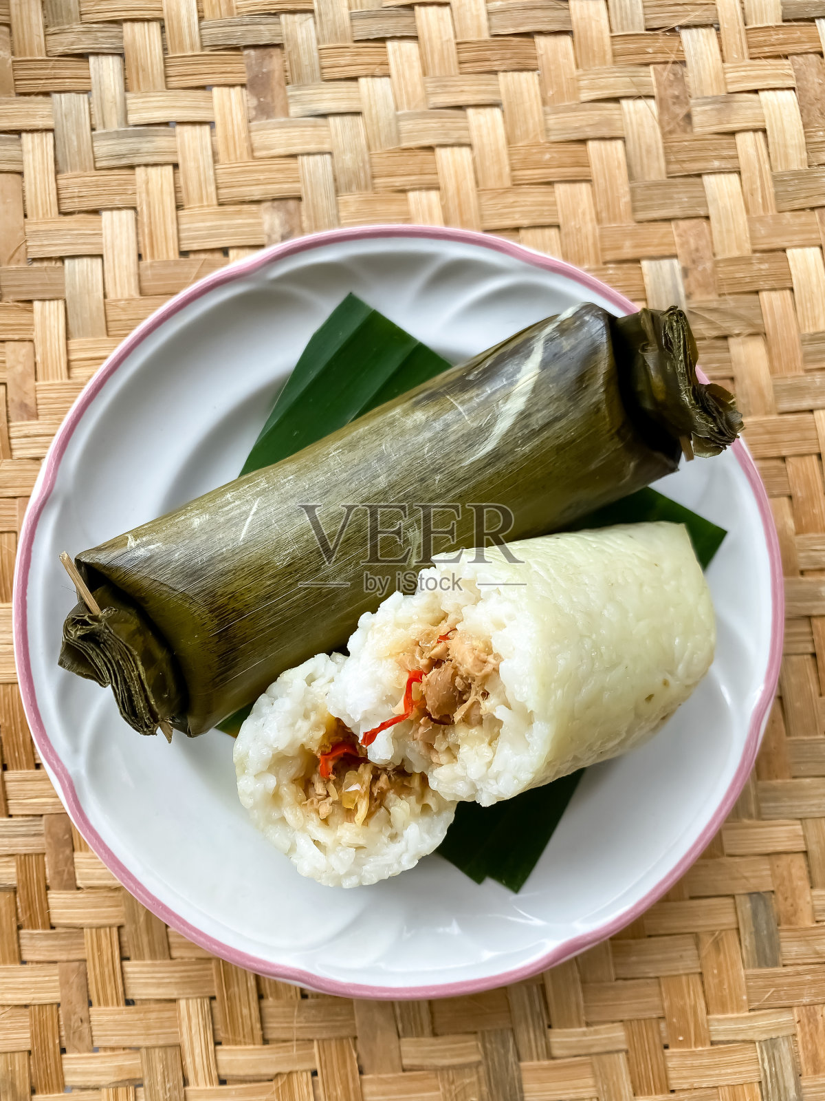 竹编上的Lemper或Arem-arem或longong的照片。用香蕉叶包裹的传统爪哇食物。照片摄影图片