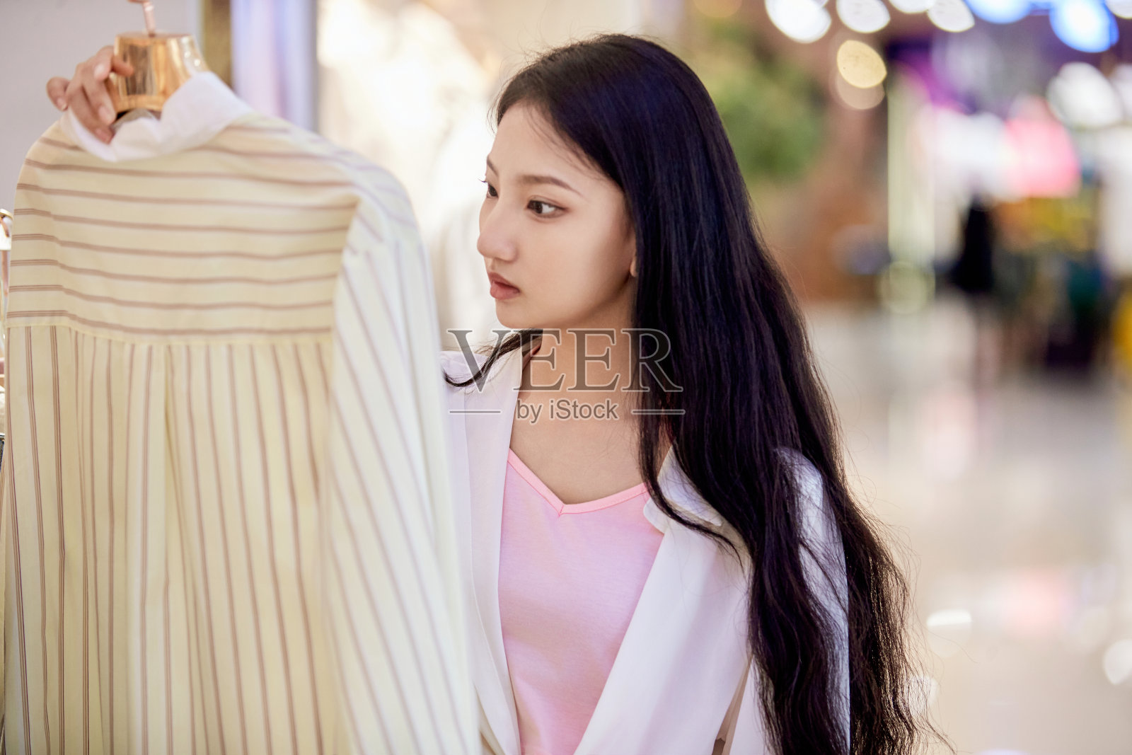 一个悠闲的十几岁的女孩在假日里漫步在商场里照片摄影图片