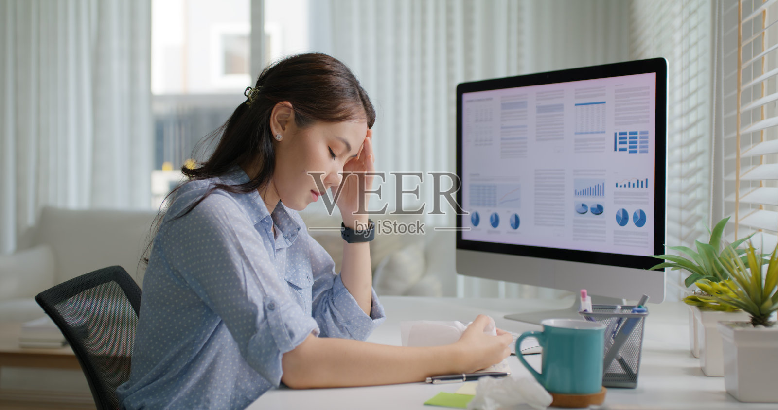 亚洲人年轻女士远程劳动力休假日感冒流感covid咳嗽流鼻涕用纸巾坐在家里办公室的桌子上。劳累不适的女性自由职业者压力疼痛。照片摄影图片