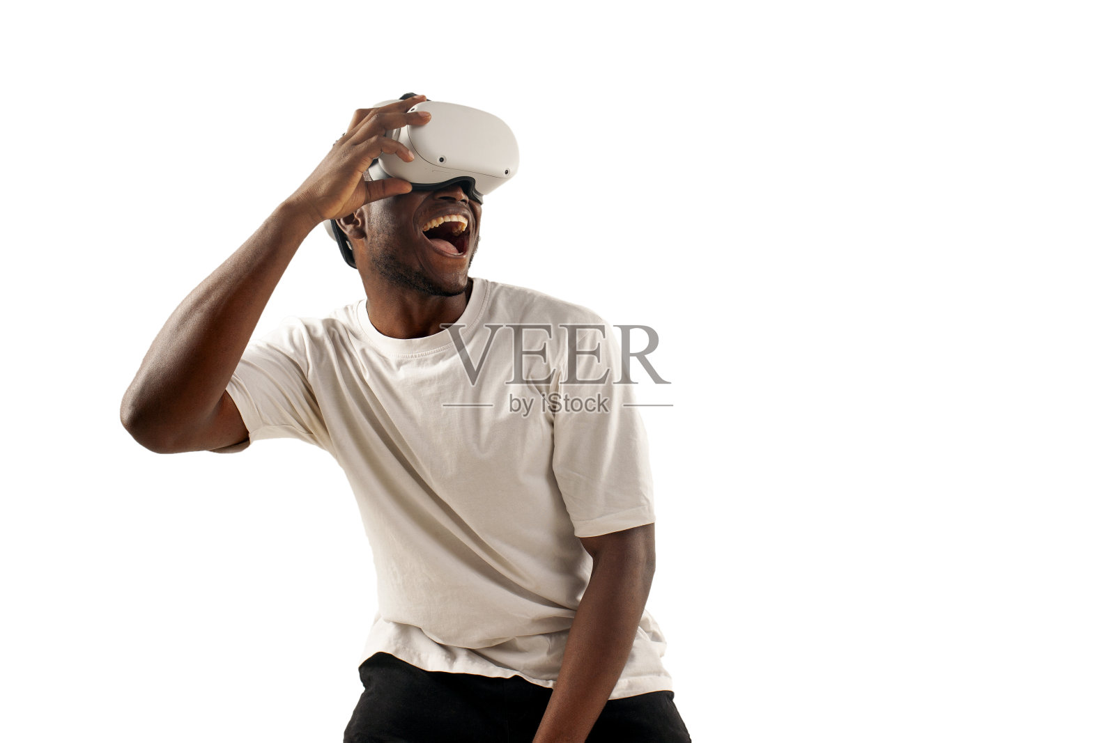 一名身穿白色t恤的非裔美国男子戴着虚拟现实眼镜望向远方，在孤立的白色背景上微笑照片摄影图片