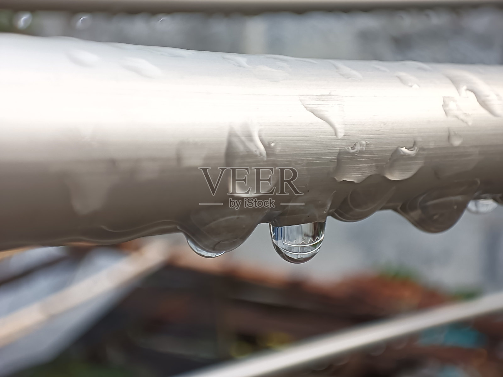 不锈钢杆上雨滴的微距特写照片摄影图片