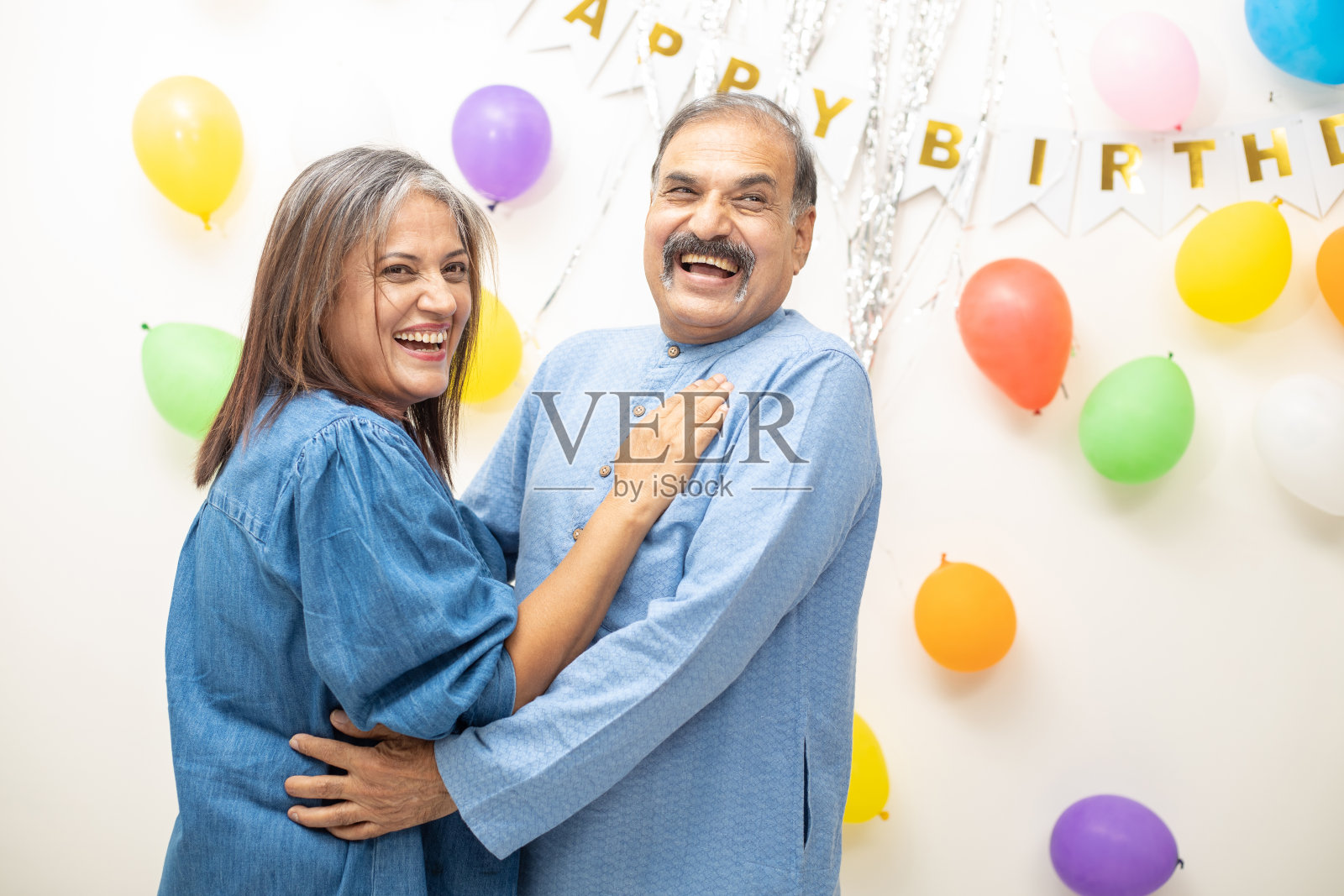 快乐的印度亚洲老夫妇庆祝生日。退休老人一起跳派对舞。照片摄影图片