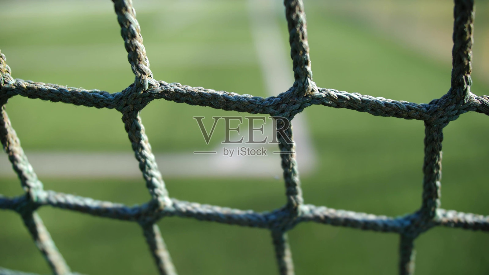 通过网架焦点看到的绿色足球场照片摄影图片