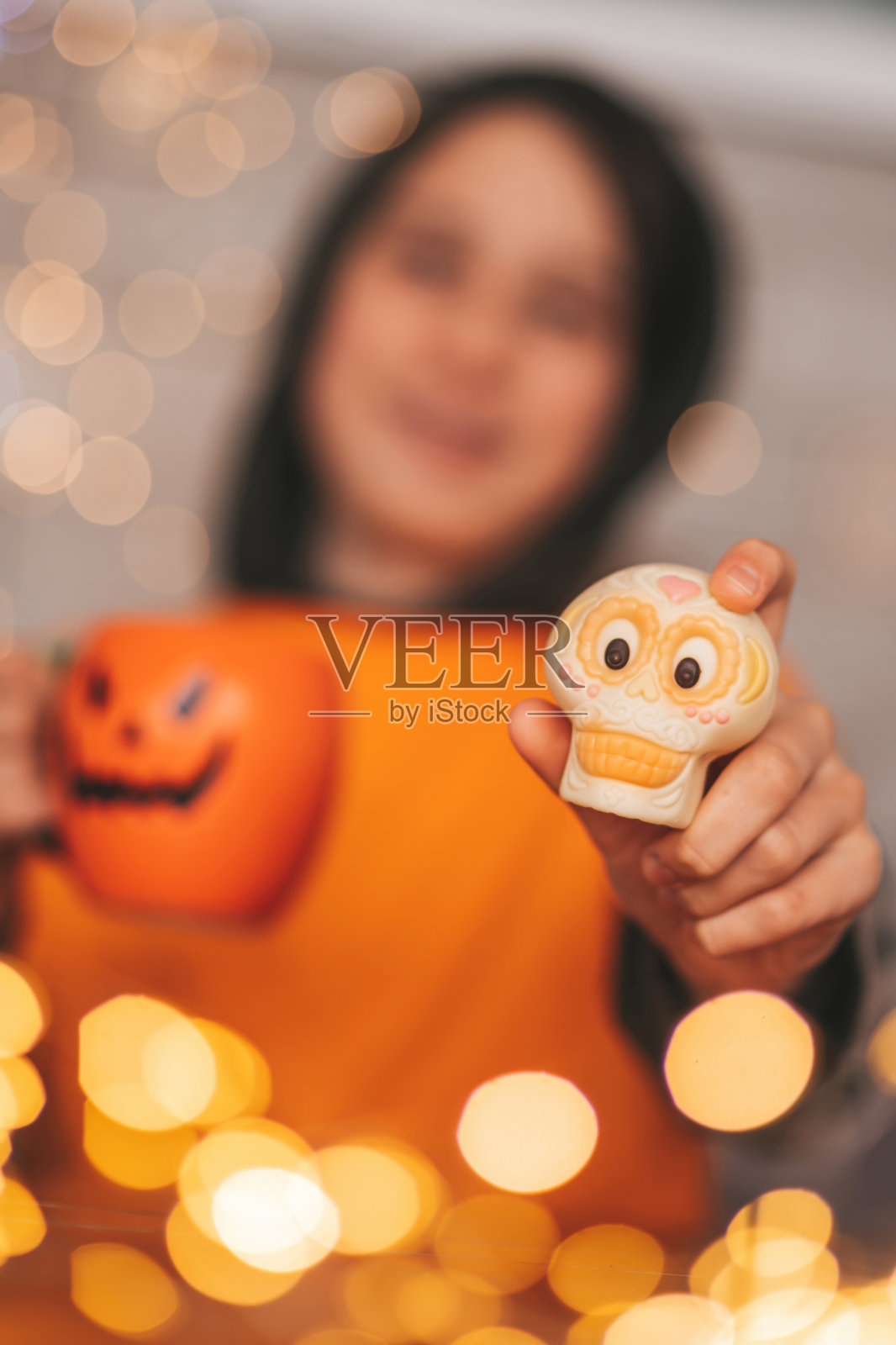 真实的变焦男孩在万圣节派对上与杰克灯笼杯子和糖果合影照片摄影图片