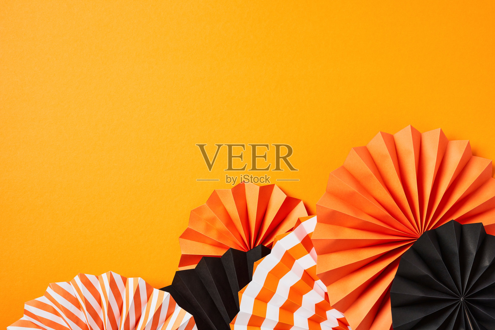 万圣节快乐的节日概念。在橙色背景上用折纸扇平铺构图照片摄影图片