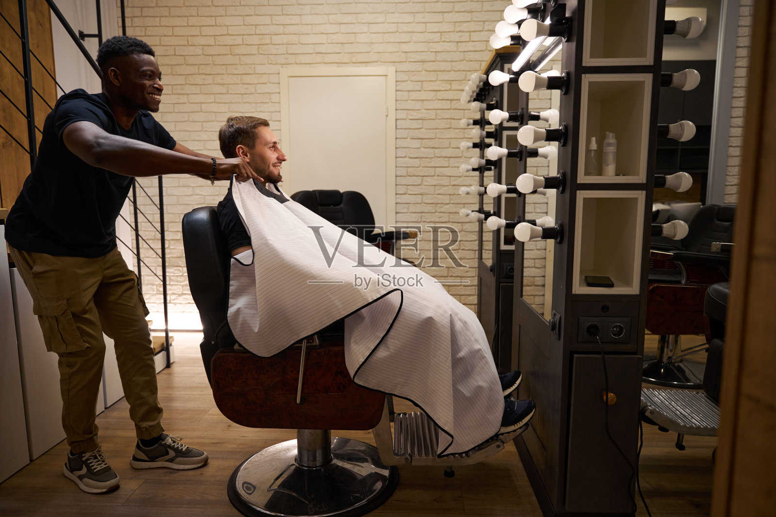 美发师为顾客披上保护斗篷照片摄影图片