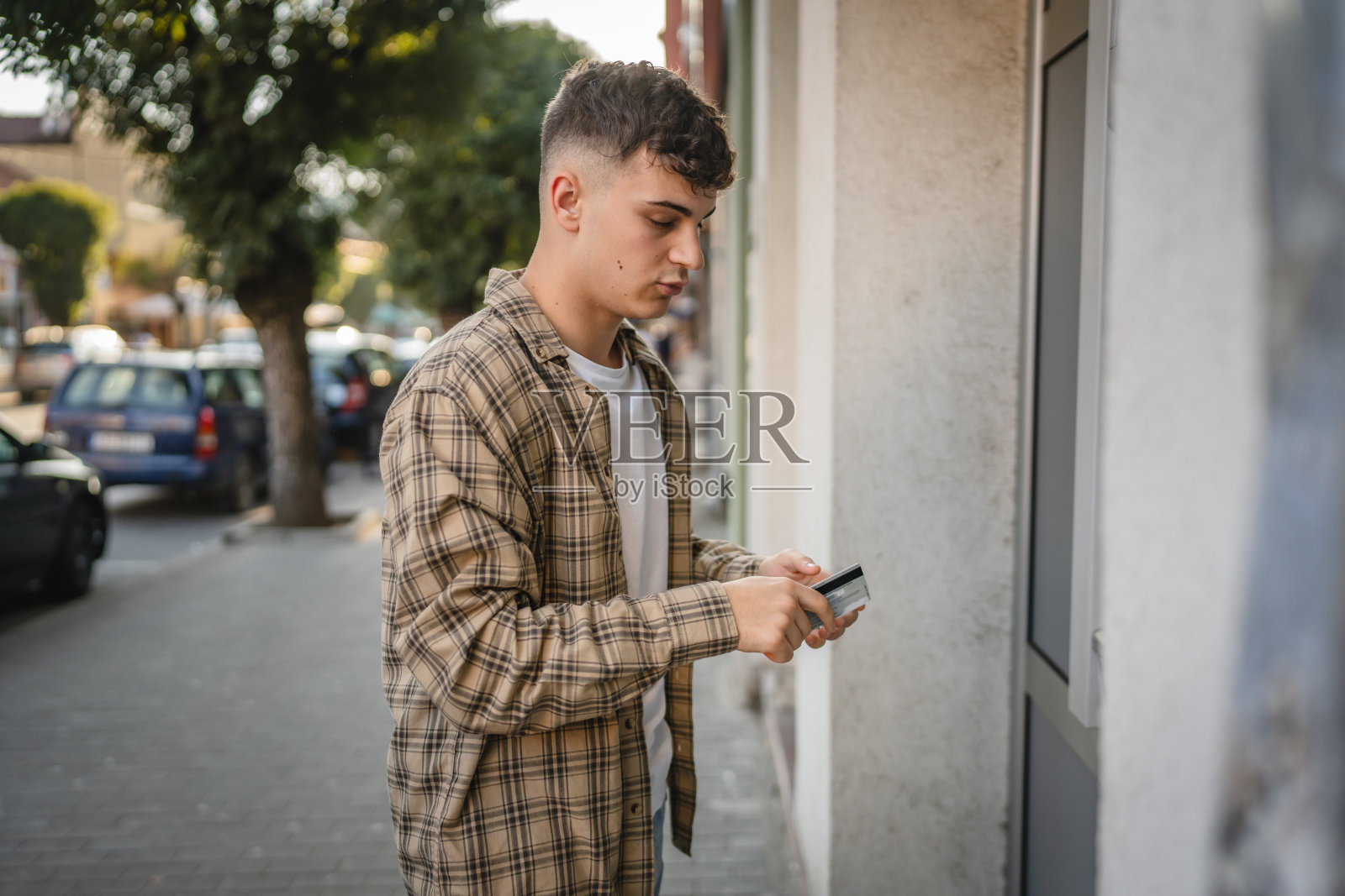 一名青少年学生用信用卡在自动取款机取钱照片摄影图片