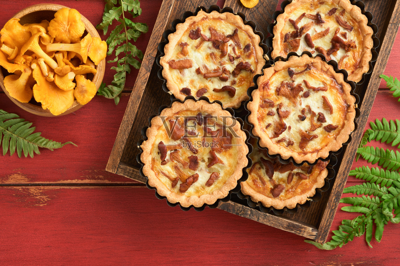 美味的手派与鸡油菌蘑菇，奶油和奶酪在砧板上的乡村老红木桌背景。自制蛋挞配季节性鸡油菌菇。乡村风格。前视图。照片摄影图片