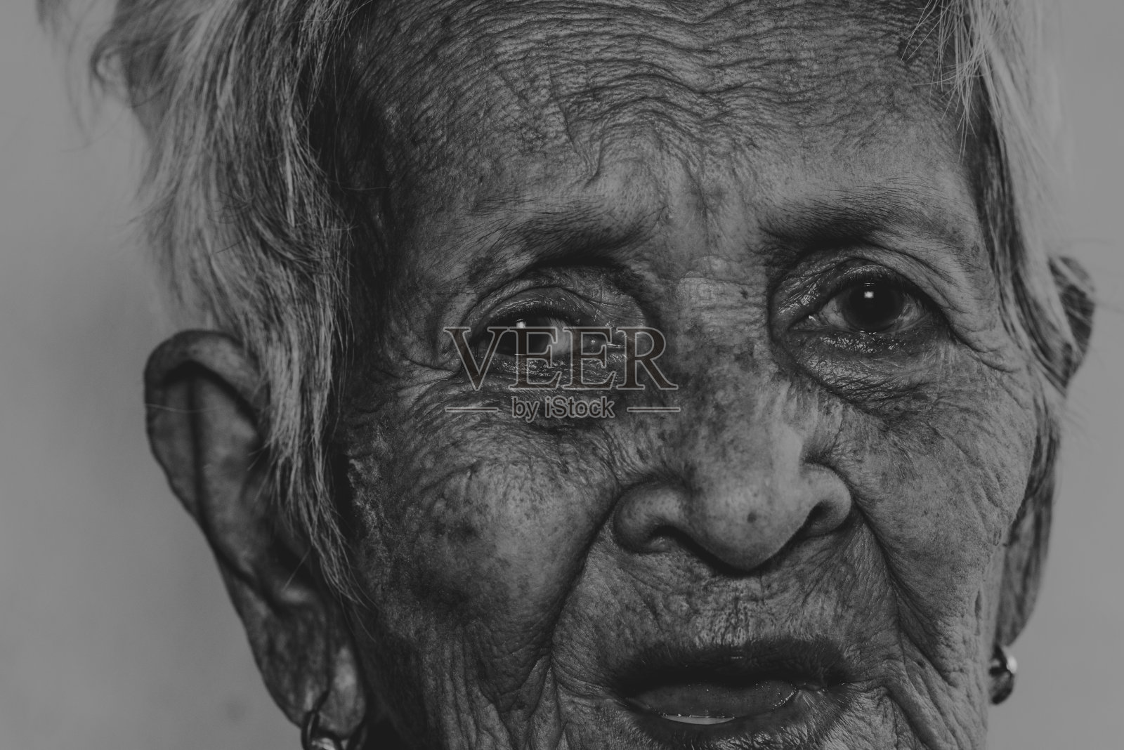 孤独地砍伐树木的老妇人（痴呆症和阿尔茨海默病）照片摄影图片