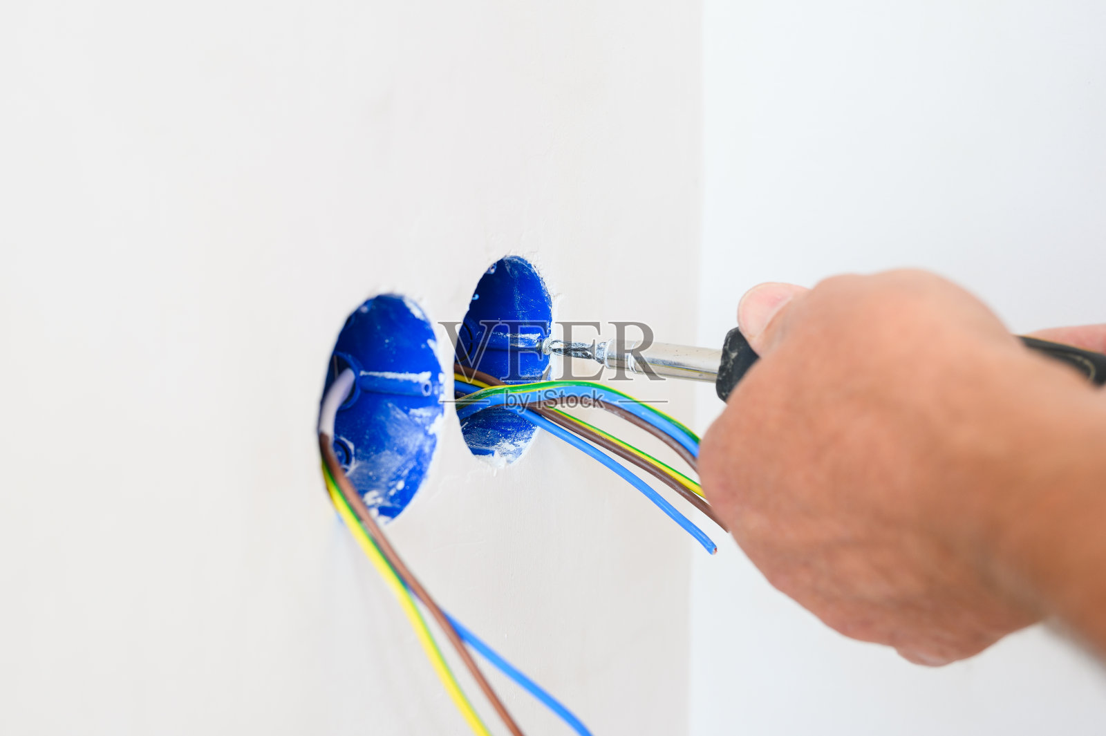 电工在墙上安装插座。照片摄影图片