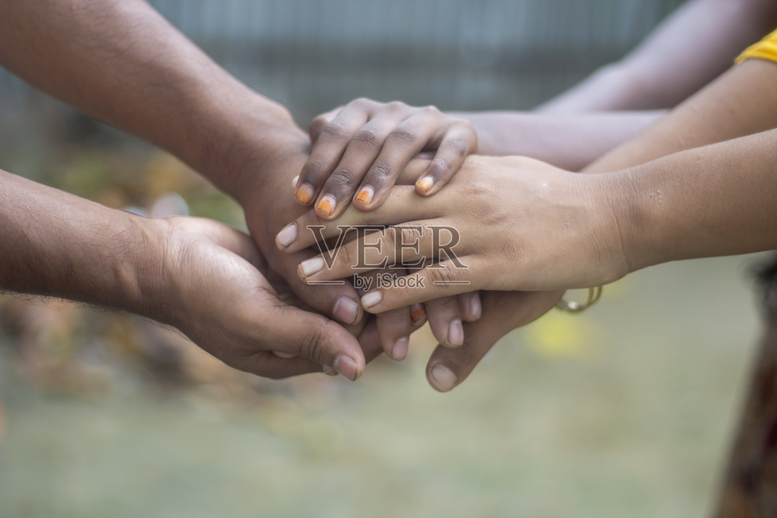 许多手叠加在一起，背景变得模糊照片摄影图片