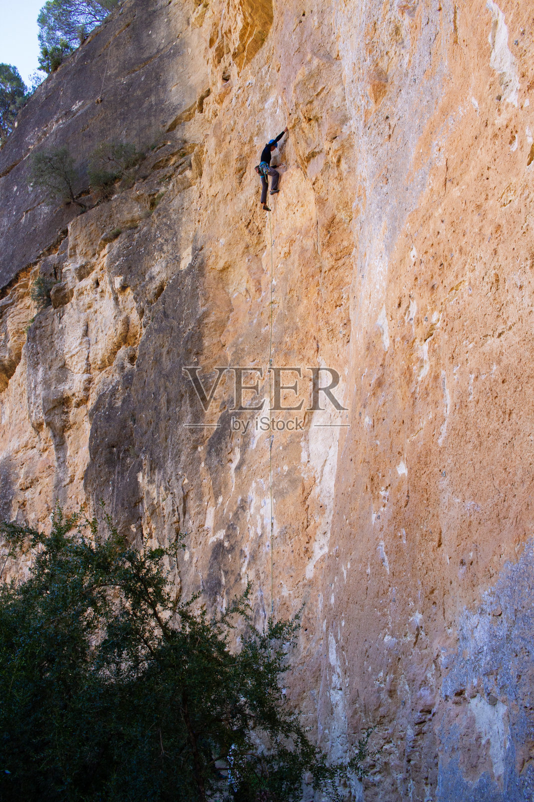 年轻人在山上爬大岩壁照片摄影图片