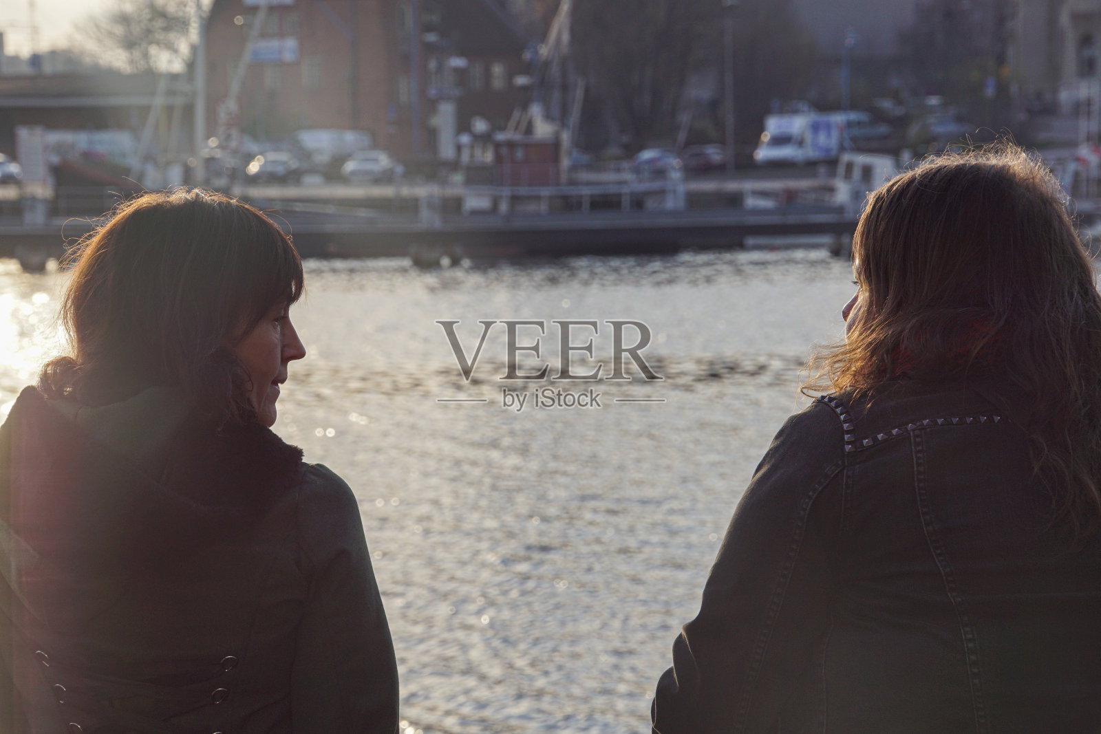 两个女人坐在河边照片摄影图片