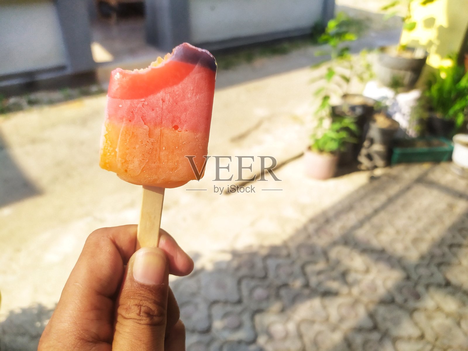 黄色、橙色和紫色的冰棒在白天被咬掉了照片摄影图片