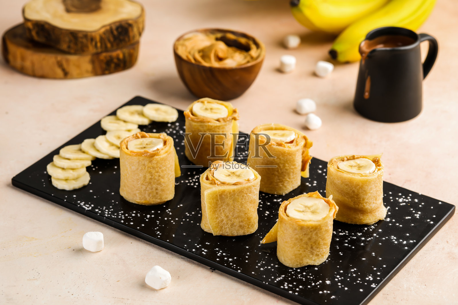 健康的香蕉可丽饼卷与巧克力在盘子隔离的桌子上看咖啡馆的食物甜点照片摄影图片