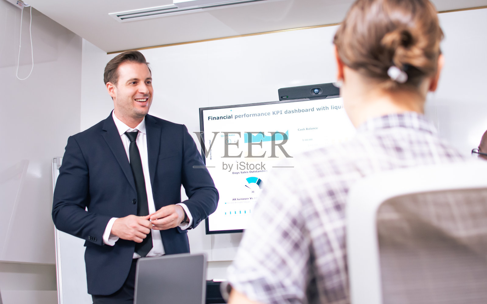 选择性关注穿着正装，面带微笑，在室内现代办公会议室向同事展示项目、金融商业计划书的白人精明商人或经理。照片摄影图片