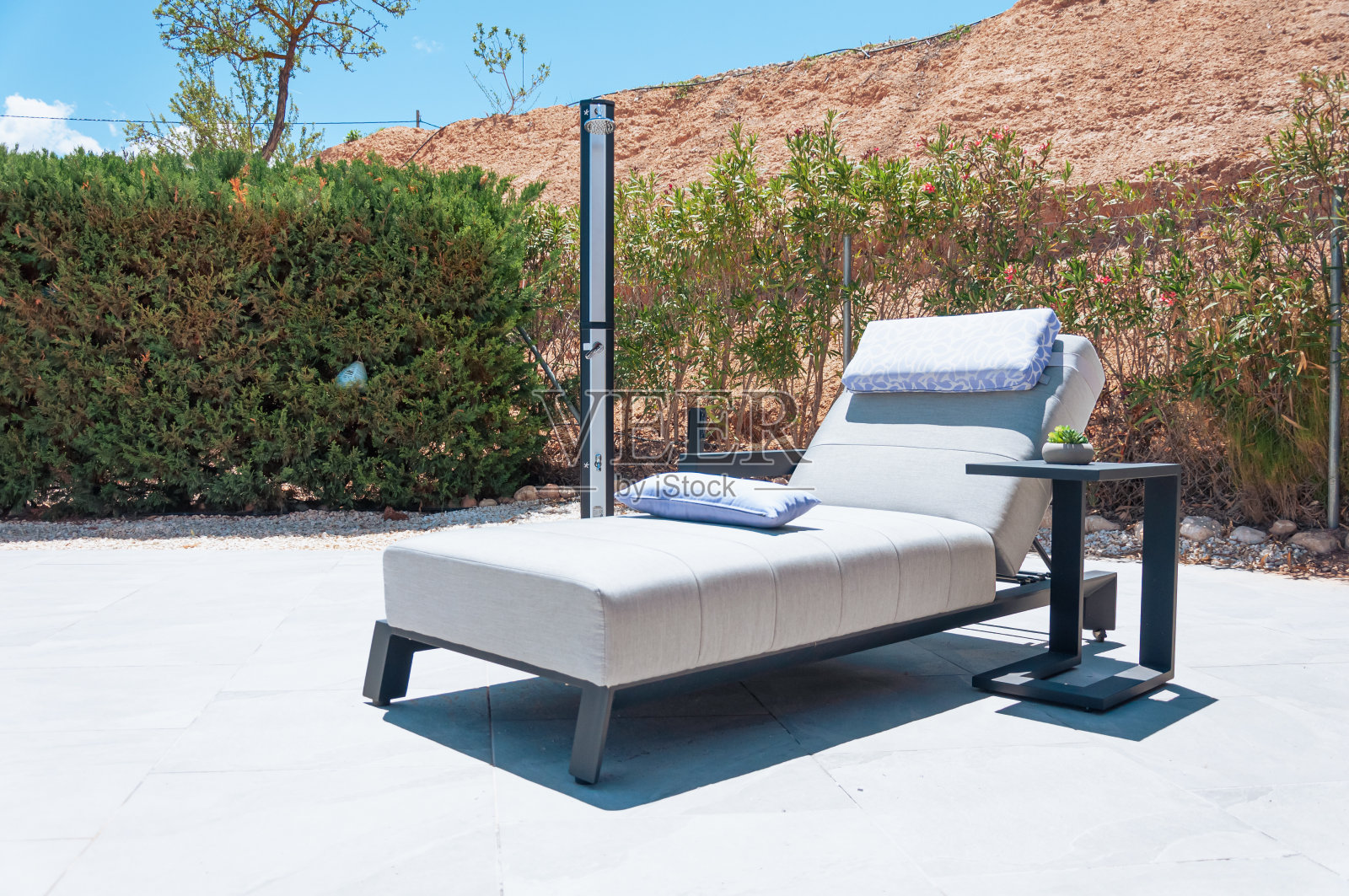 现代躺椅在一个昂贵的酒店周围的绿色植物和山脉的特写照片摄影图片