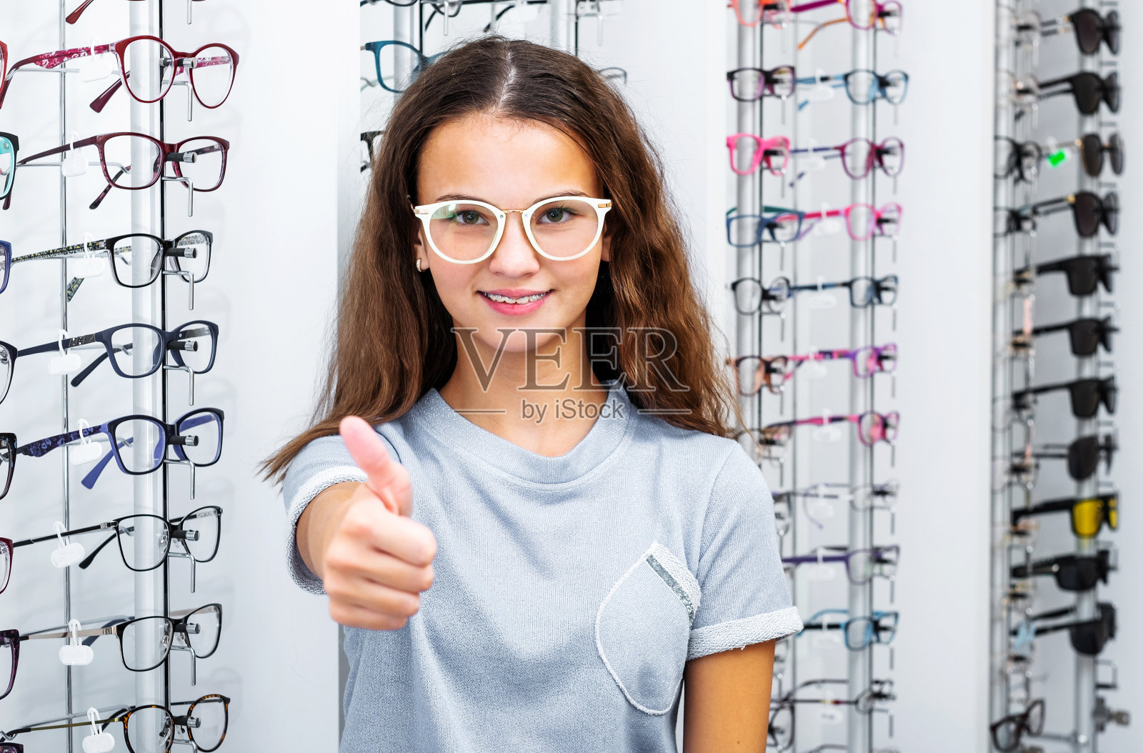 十几岁的女孩站在眼镜店竖起大拇指照片摄影图片
