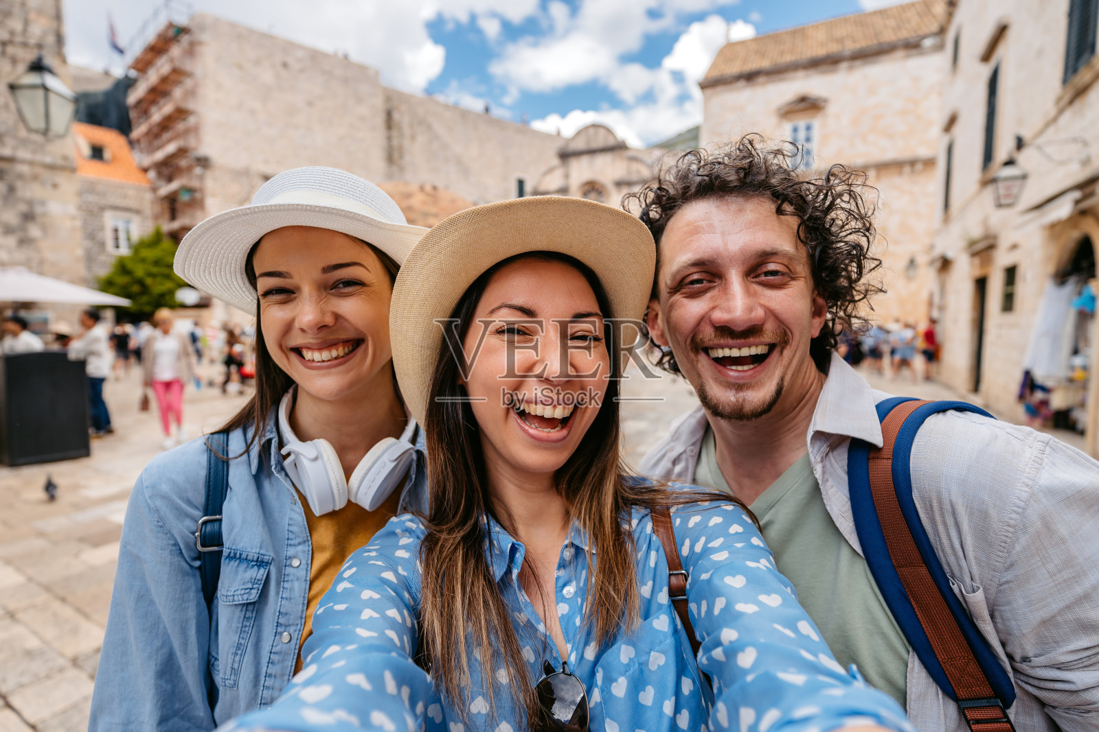 三个年轻的朋友在杜布罗夫尼克的城市广场上自拍照片摄影图片