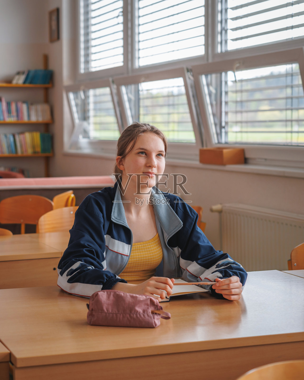 坐在课桌前的少女照片摄影图片