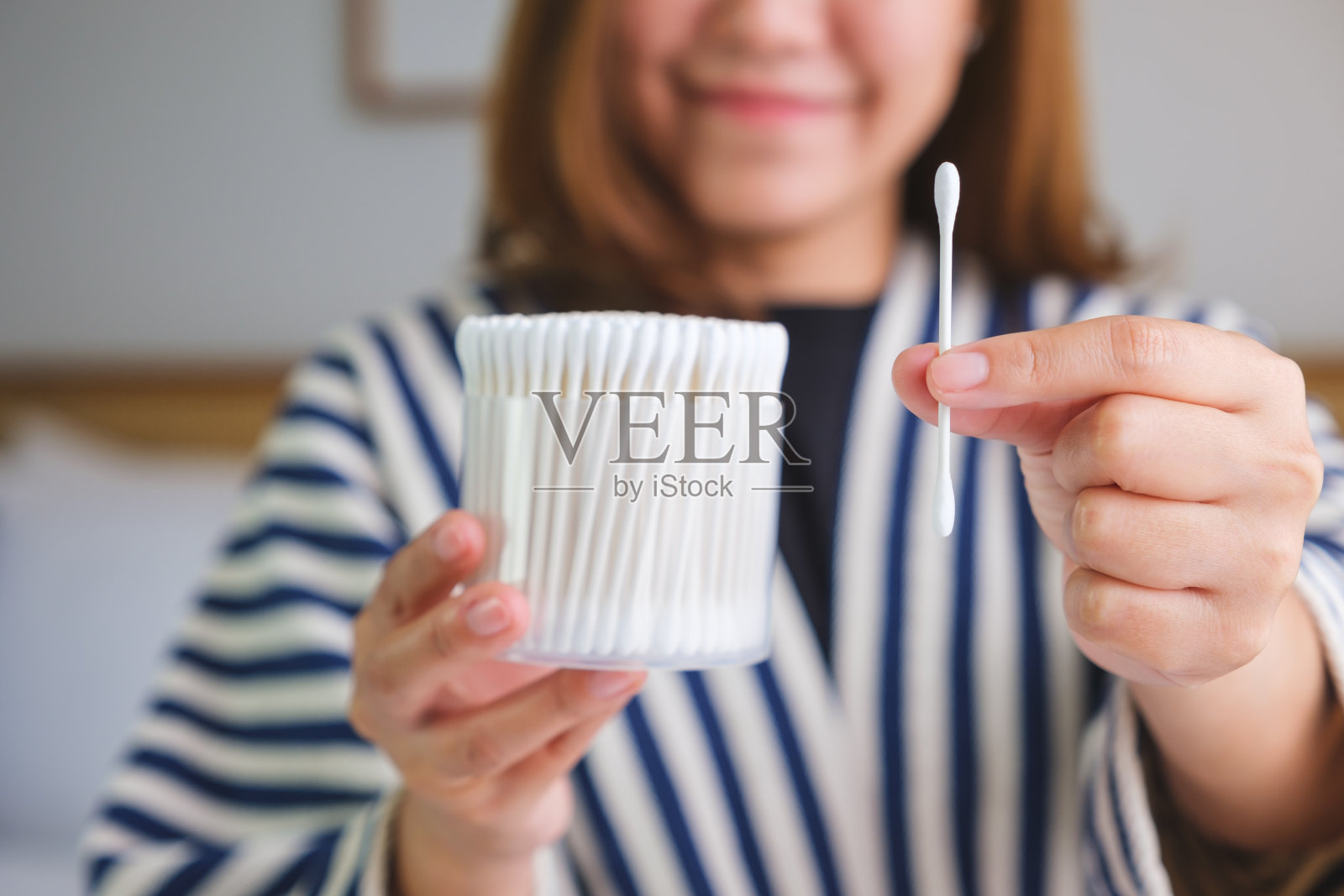 一个妇女在家里拿着棉签的特写照片照片摄影图片