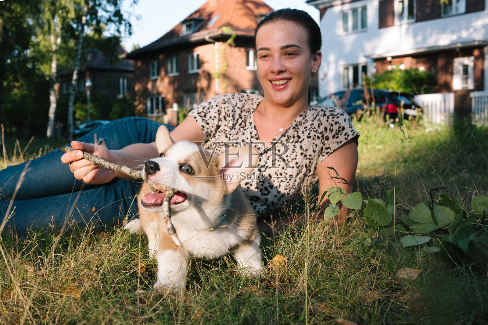 肖像:年轻女子和她的柯基小狗玩耍照片摄影图片
