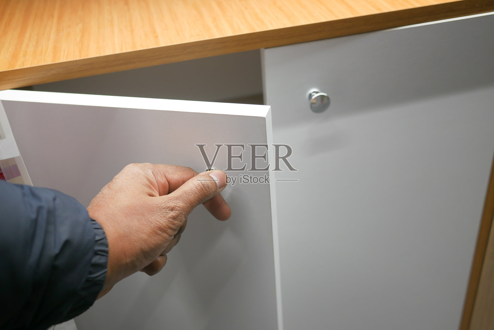 男人的手打开橱柜里的木制抽屉照片摄影图片