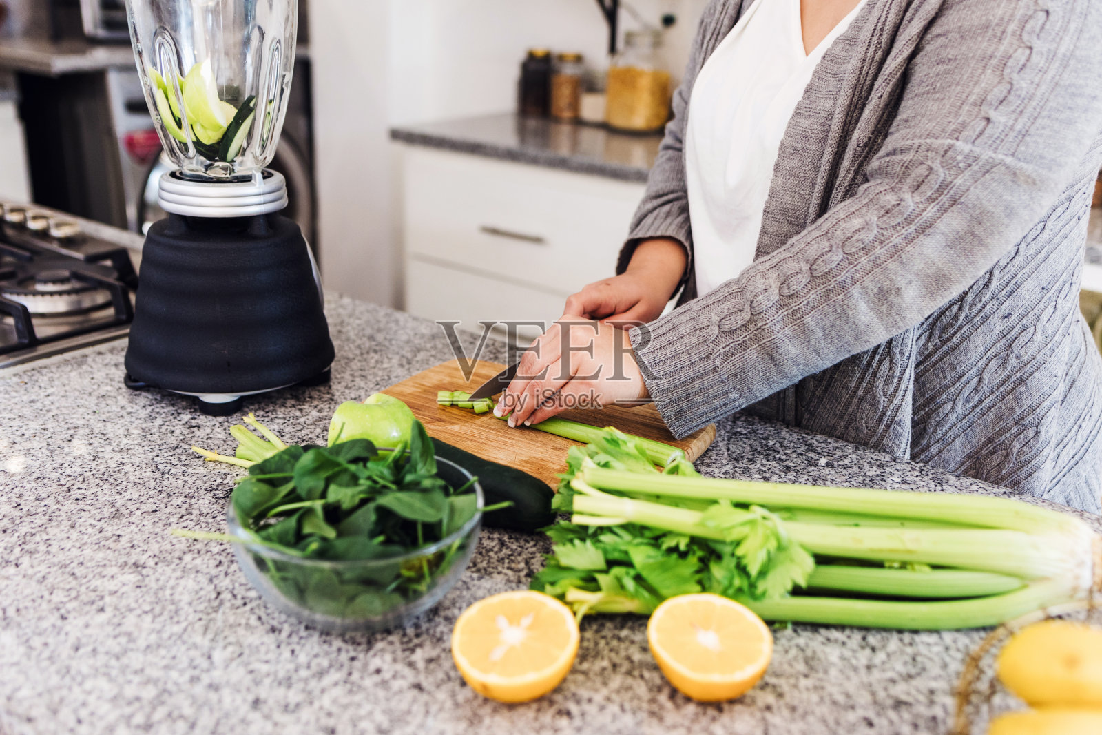 超重的拉丁美洲妇女在墨西哥家里的厨房里准备排毒或绿色果汁拉丁美洲，西班牙裔女性加码照片摄影图片