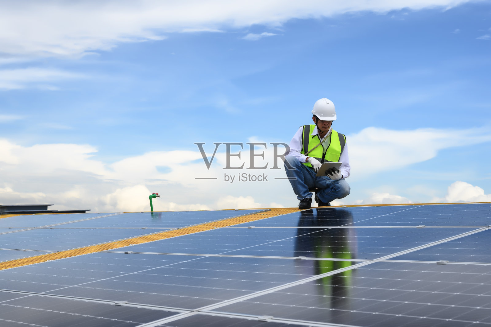 太阳能屋顶板安装质量督察工程师，使用App技术检查平板上太阳能板的累计发电量。可持续建筑光伏工程。照片摄影图片