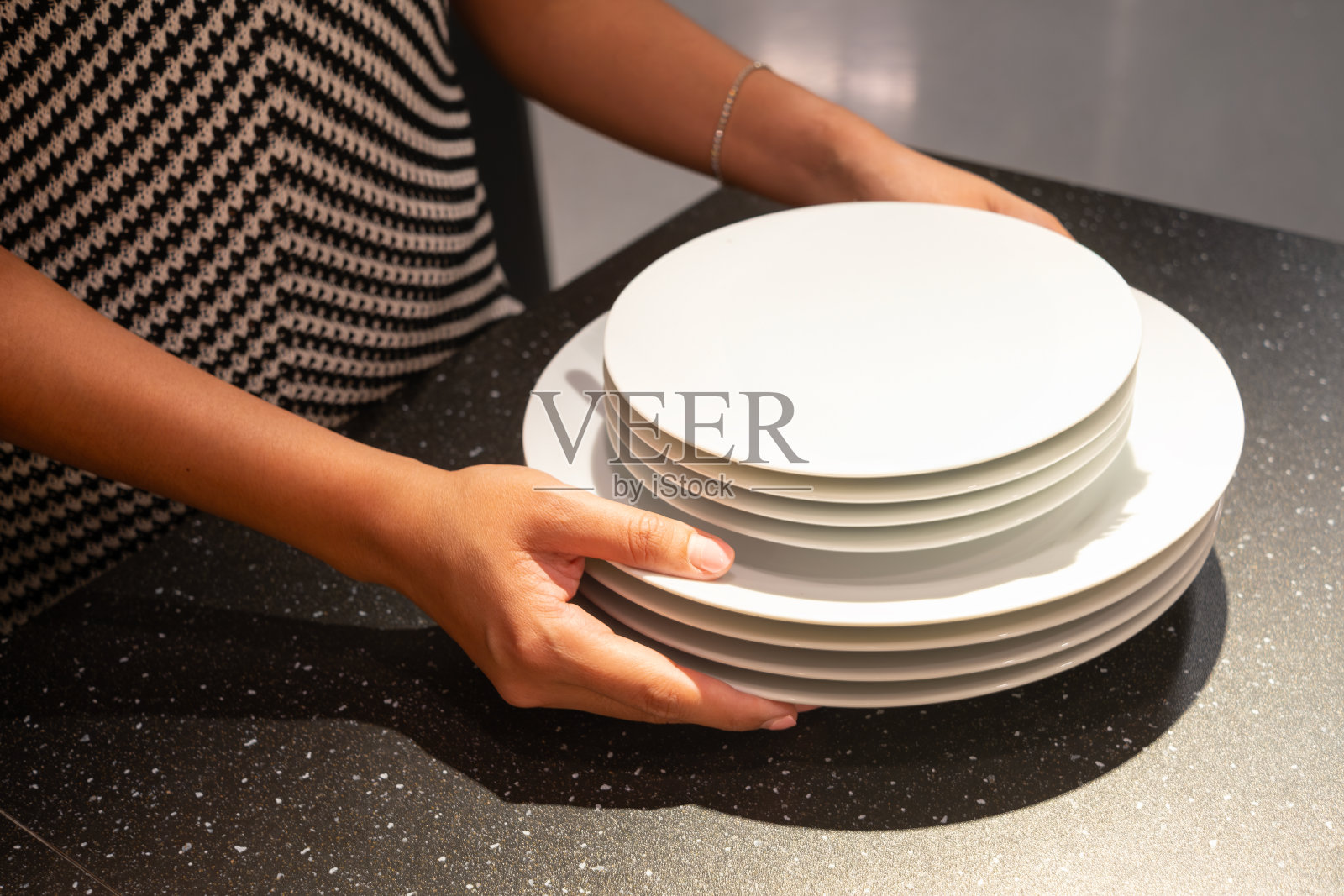 女士准备盘子和餐具为晚宴准备餐桌。照片摄影图片