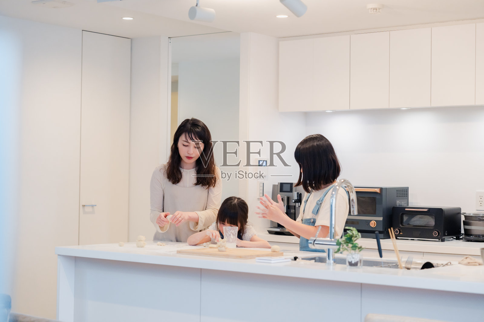 孩子们和妈妈一起做饭照片摄影图片