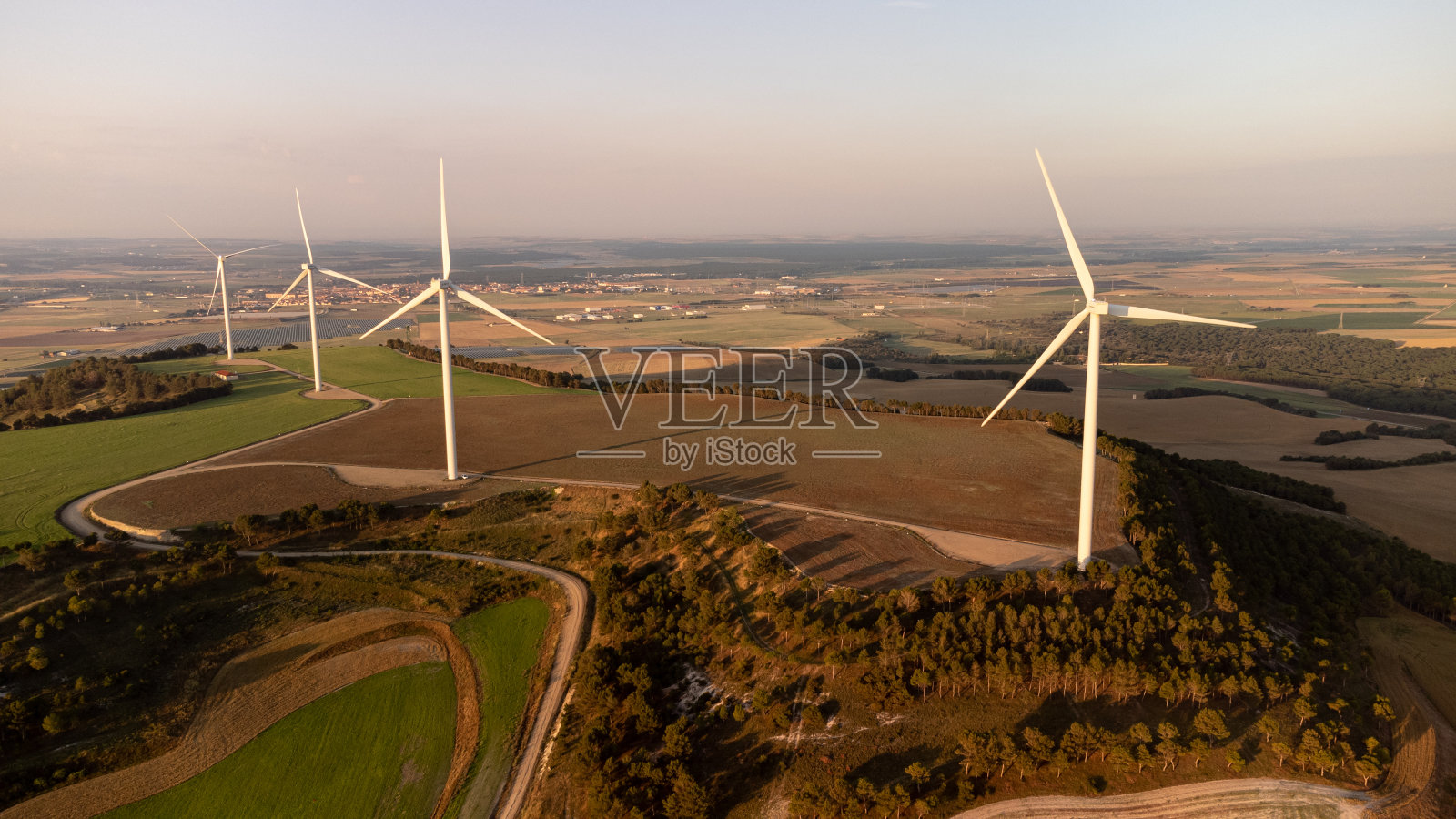 在山顶上有四个涡轮机的小型风力发电场照片摄影图片