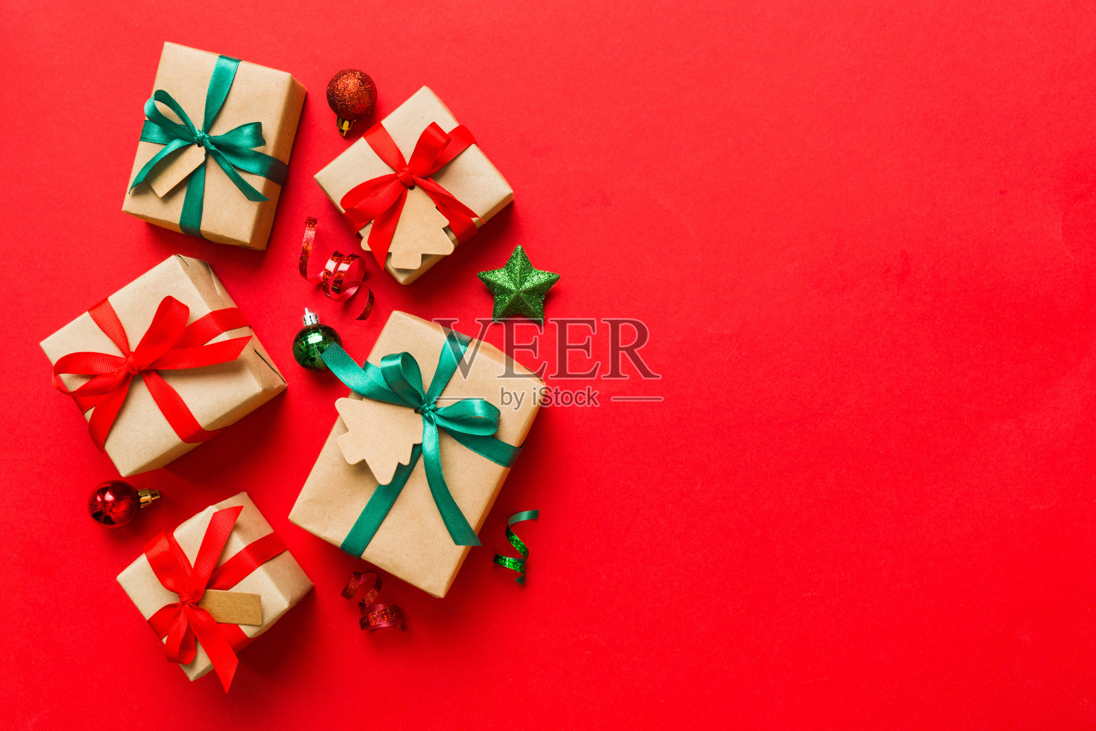用彩带把圣诞节或其他节日手工制作的礼物用纸包好。礼品盒，彩色桌子上的礼品装饰，顶部视图与复制空间照片摄影图片