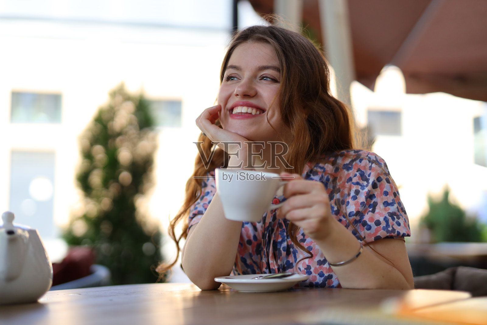 迷人的女人在城市咖啡馆享受早晨的饮料，散发出愉快和放松的氛围。照片摄影图片