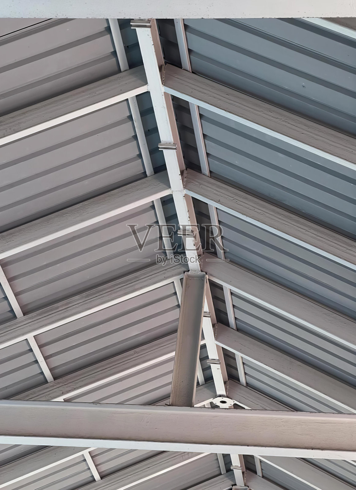 一张带有时钟的金属屋顶的照片，一张带有金属梁和时钟的拱形屋顶的照片。照片摄影图片